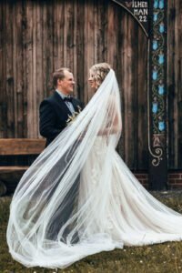 Hochzeitsfotografin Berlin: Brautpaar schaut sich an und der Schleier fliegt vor ihnen.