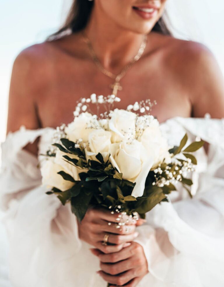Braut hält weißen Blumenstrauß und wird von der Hochzeitsfotografin aus Berlin fotografiert.