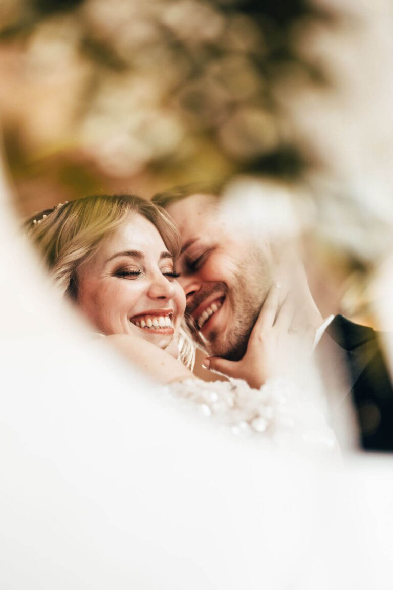 Das Brautpaar ist eng umschlungen und spiegelt sich im Spiegel.